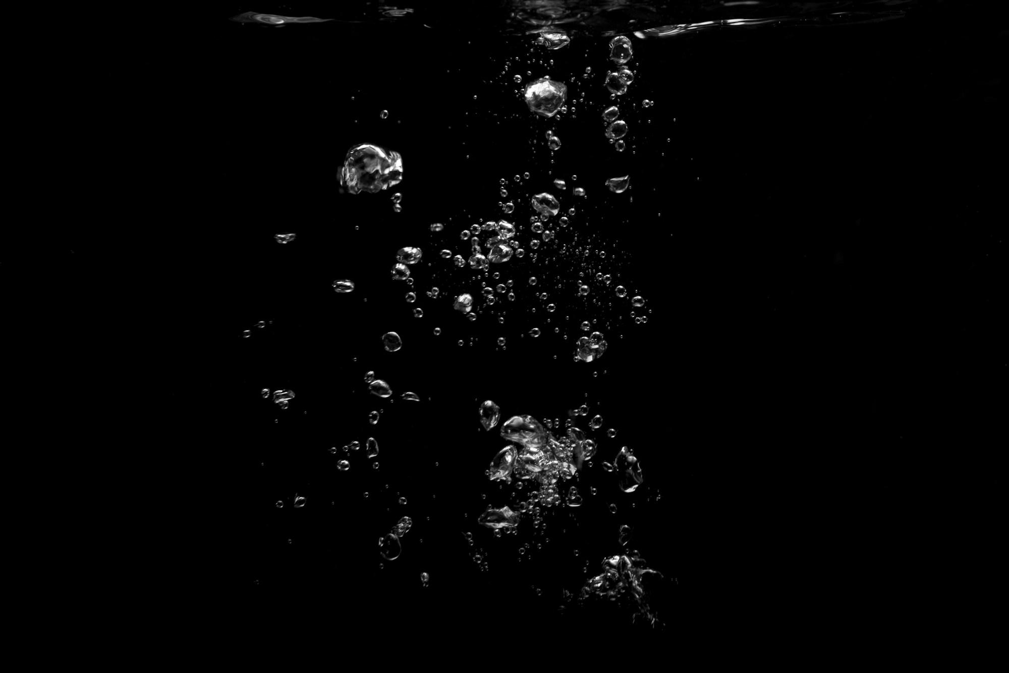 Manantial subterráneo iluminado — agua clara ascendiendo desde la roca volcánica de la Sierra de Zongolica